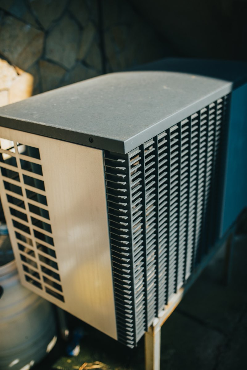 Outdoor condenser unit installed beside a house